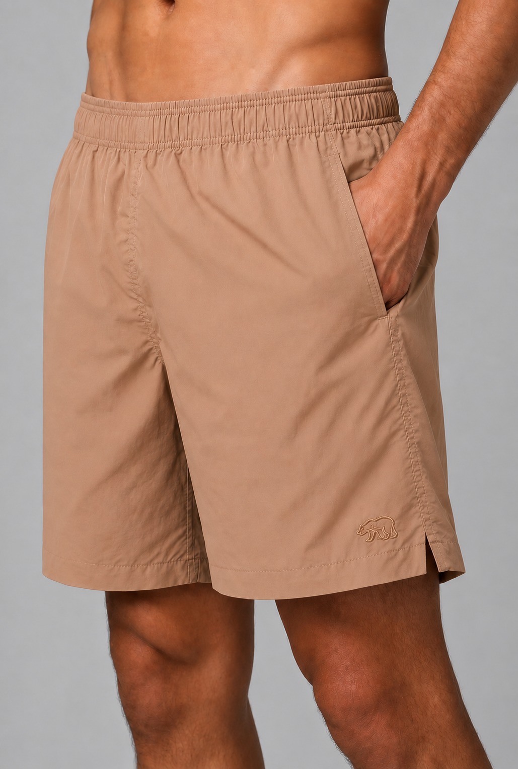 Detalhe de short de tactel caramelo Bransk com bolso lateral e urso bordado tom sobre tom