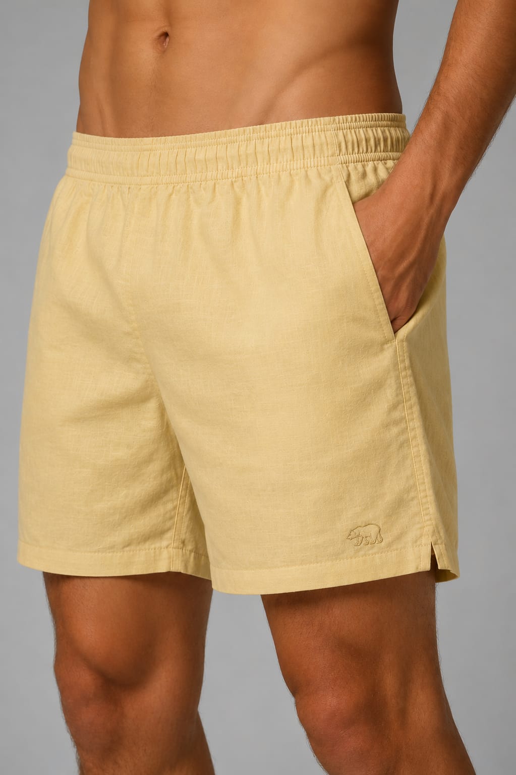 Detalhe de short de linho amarelo-claro Bransk com cós elástico e urso bordado